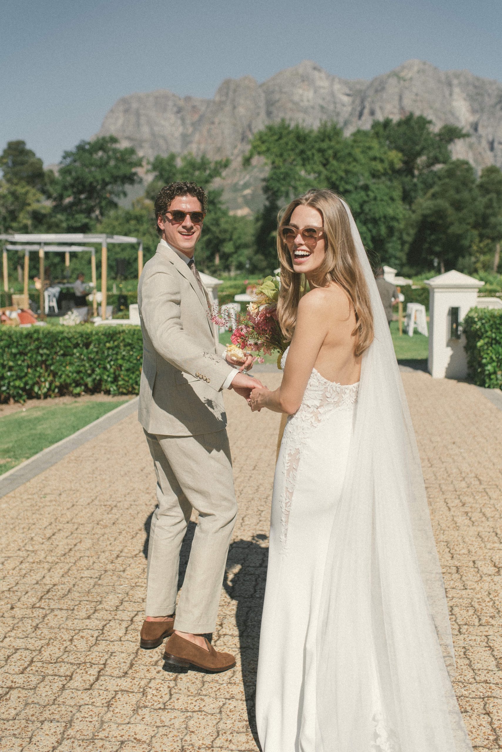 groom in beige linen wedding suit with his bride