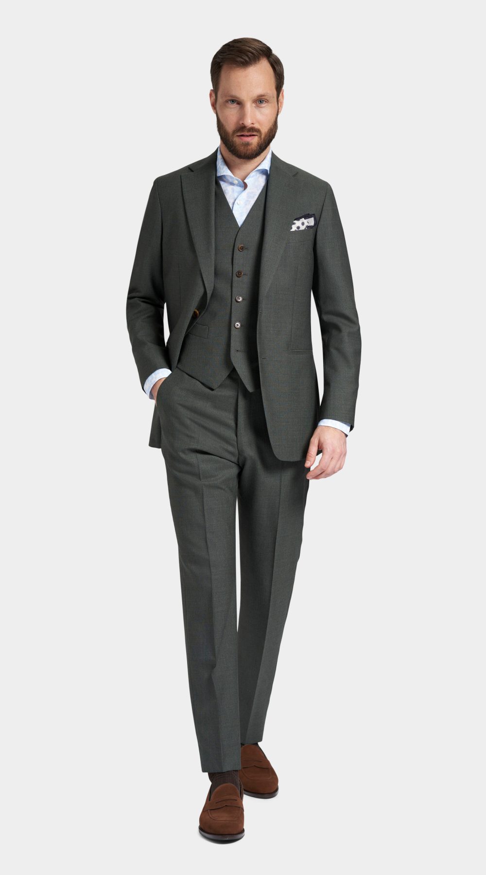 full body picture of a man in Green grey three piece wedding suit, with a white paisley pocket square and brown suede leather loafers