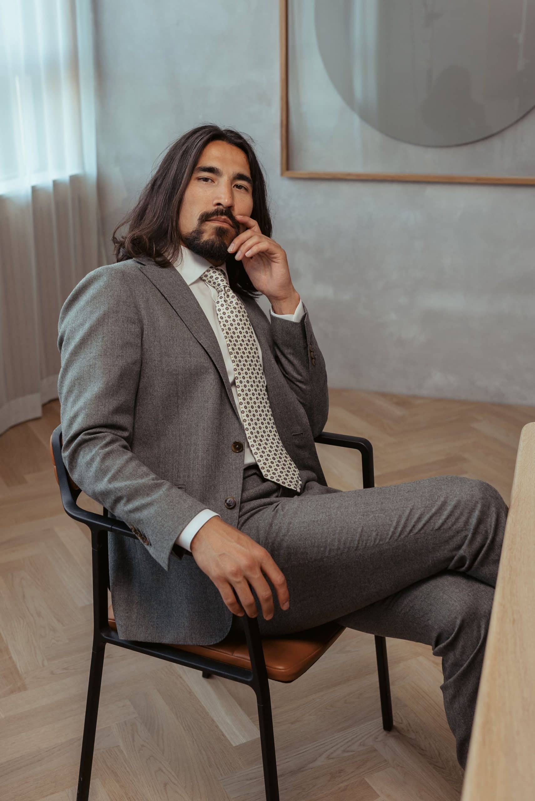 Man sitting in two-piece grey suit custom made by mond