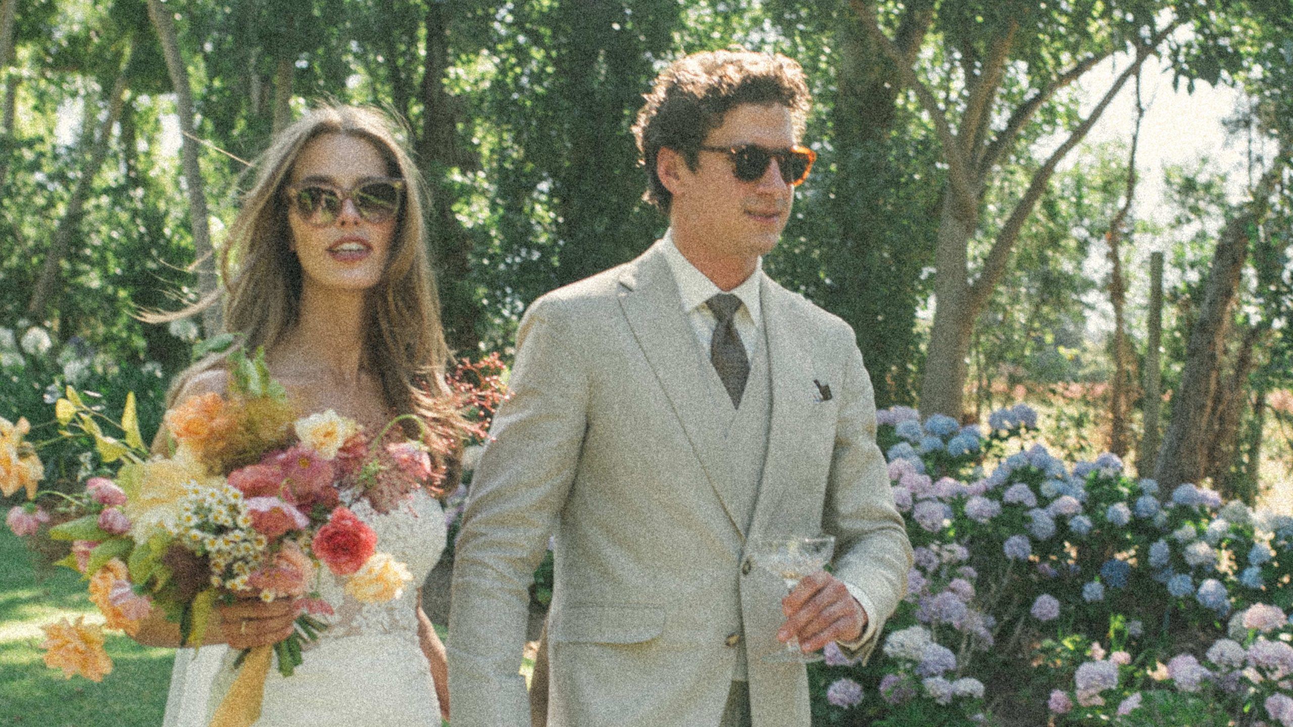 Bride and groom with sunglasses and tailored beige linen suit