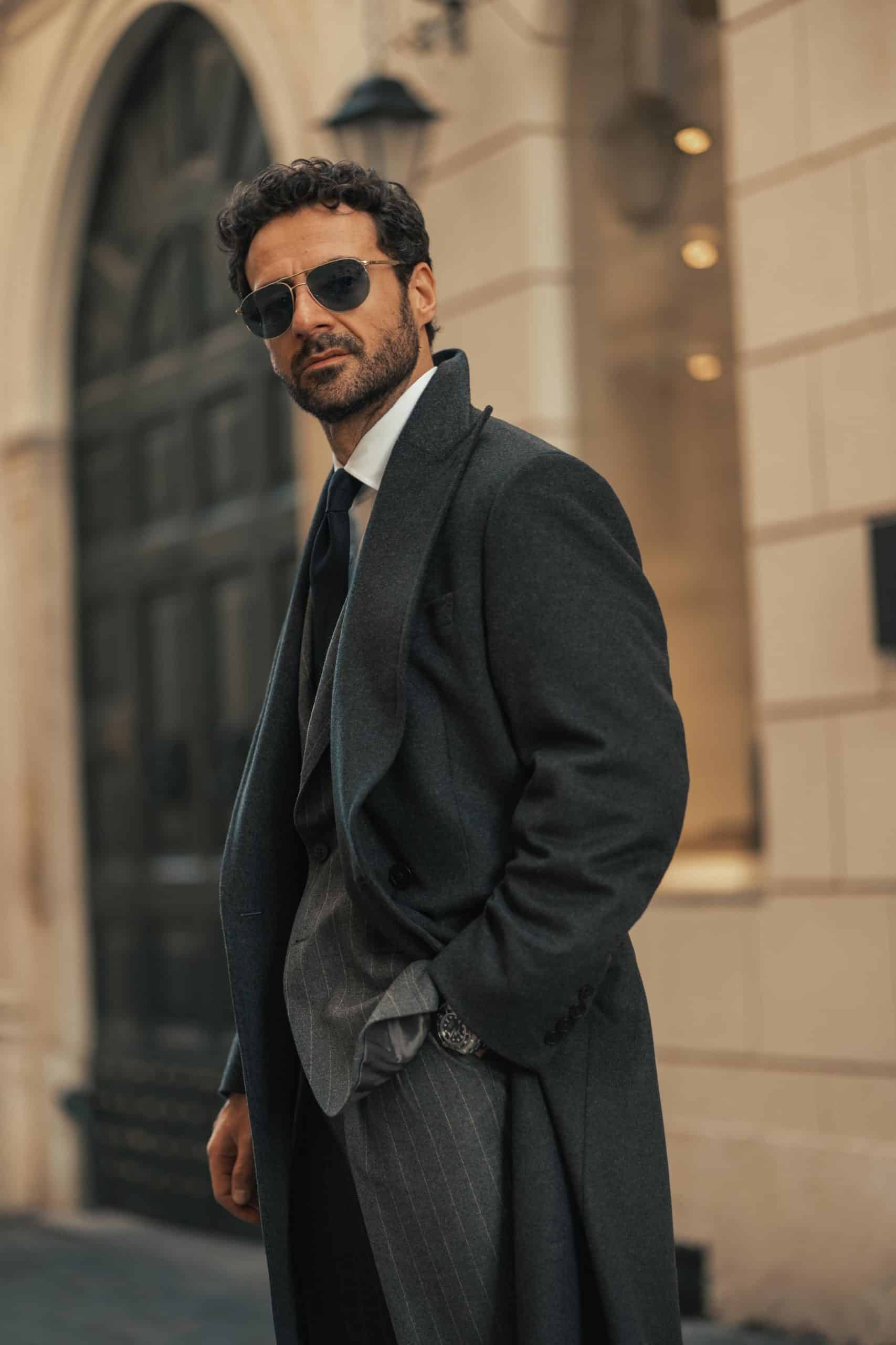 Giorgio giangiulio wearing a custom mond chalkstripe grey suit and a charcoal grey overcoat