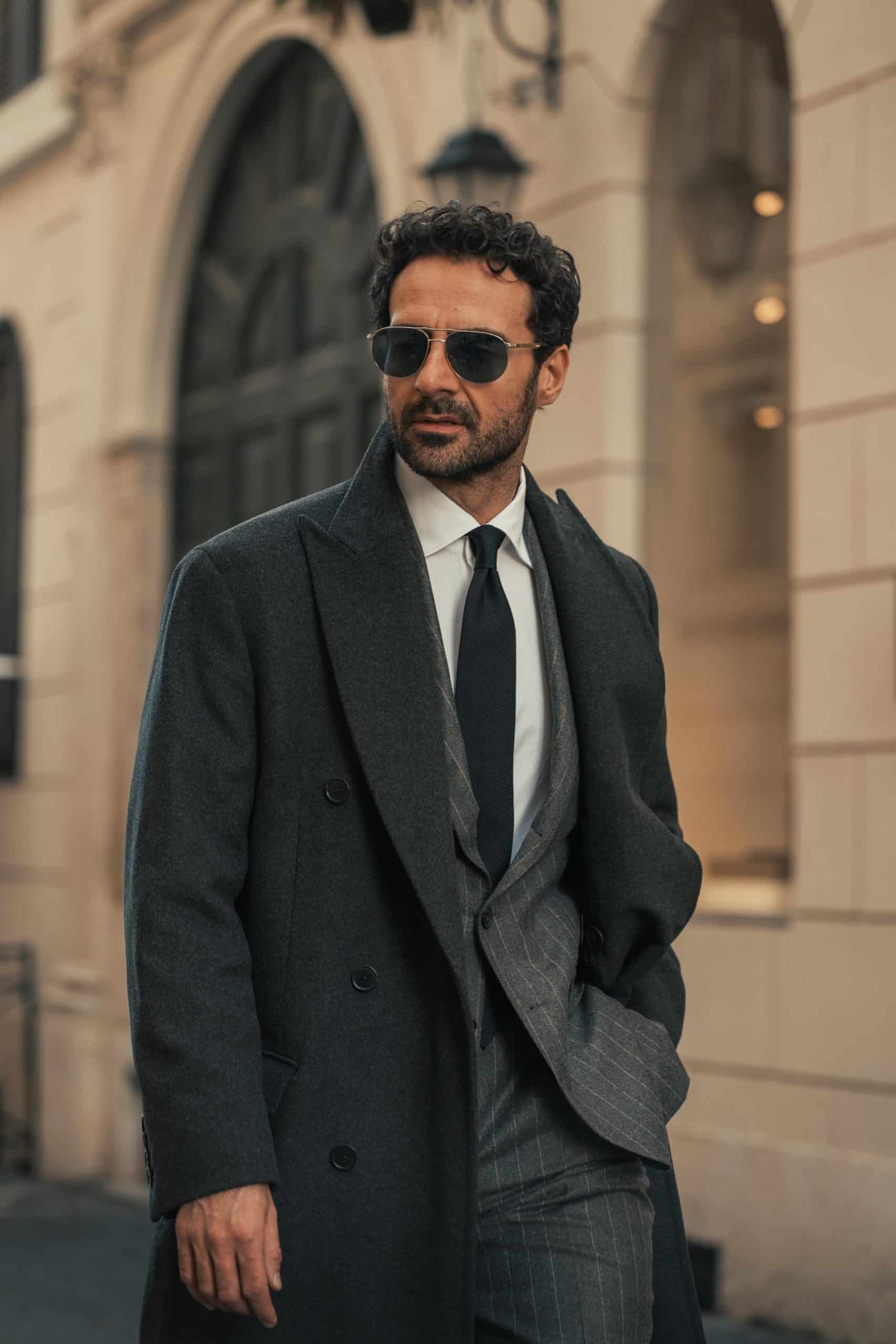Giorgio giangiulio wearing custom mademond chalkstripe grey suit and a charcoal grey overcoat
