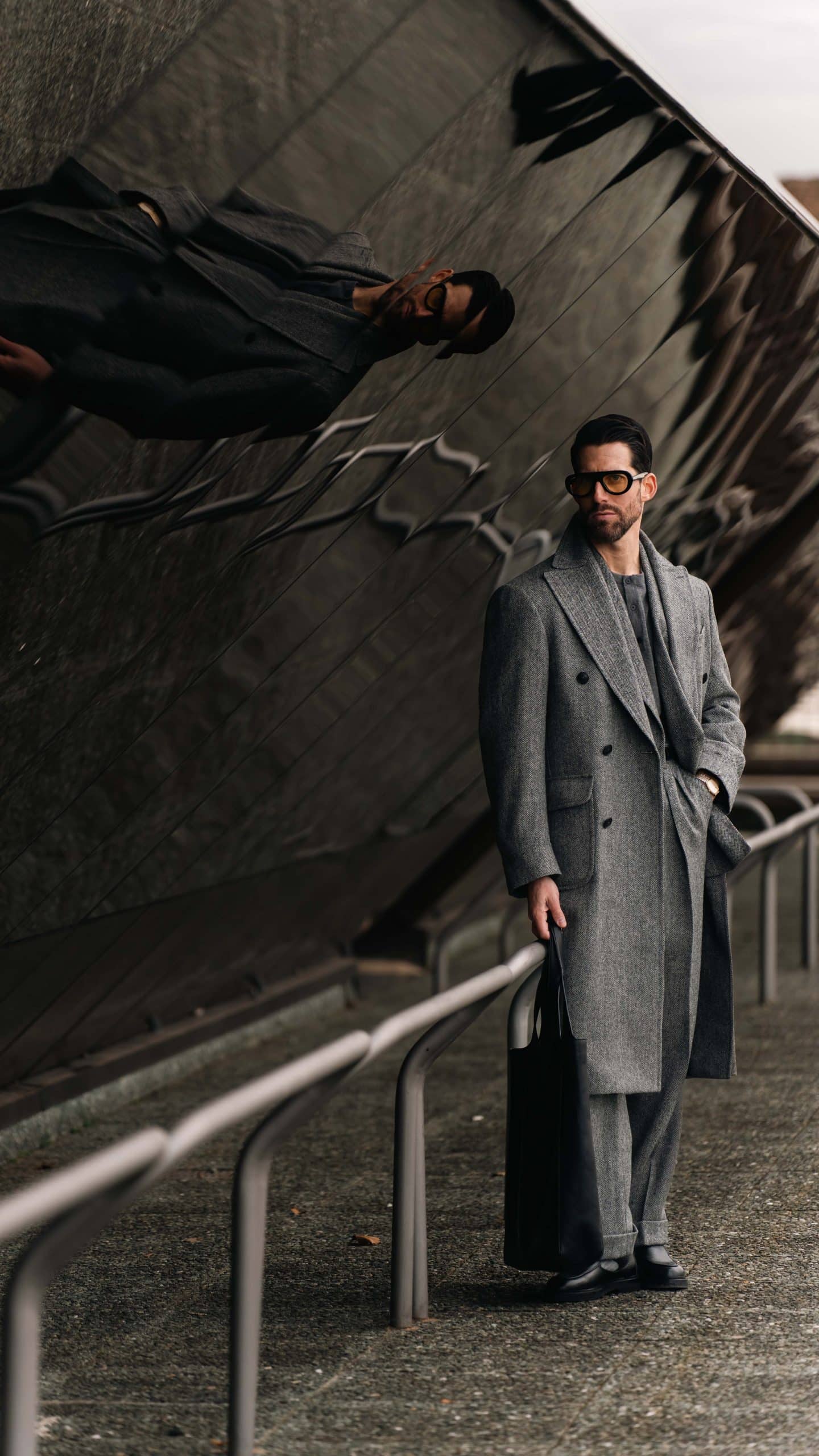 The monochrome charcoal herringbone suit with a matching overcoat, custom made by mond of copenhagen, worn by carlos domord at pitti uomo