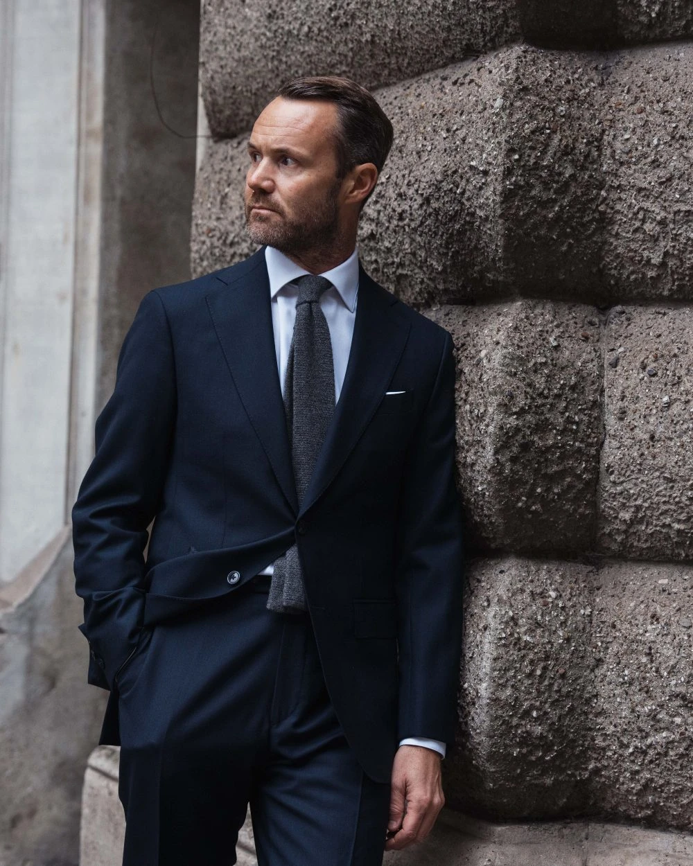 man in navy blue wedding suit and knit wool tie in grey