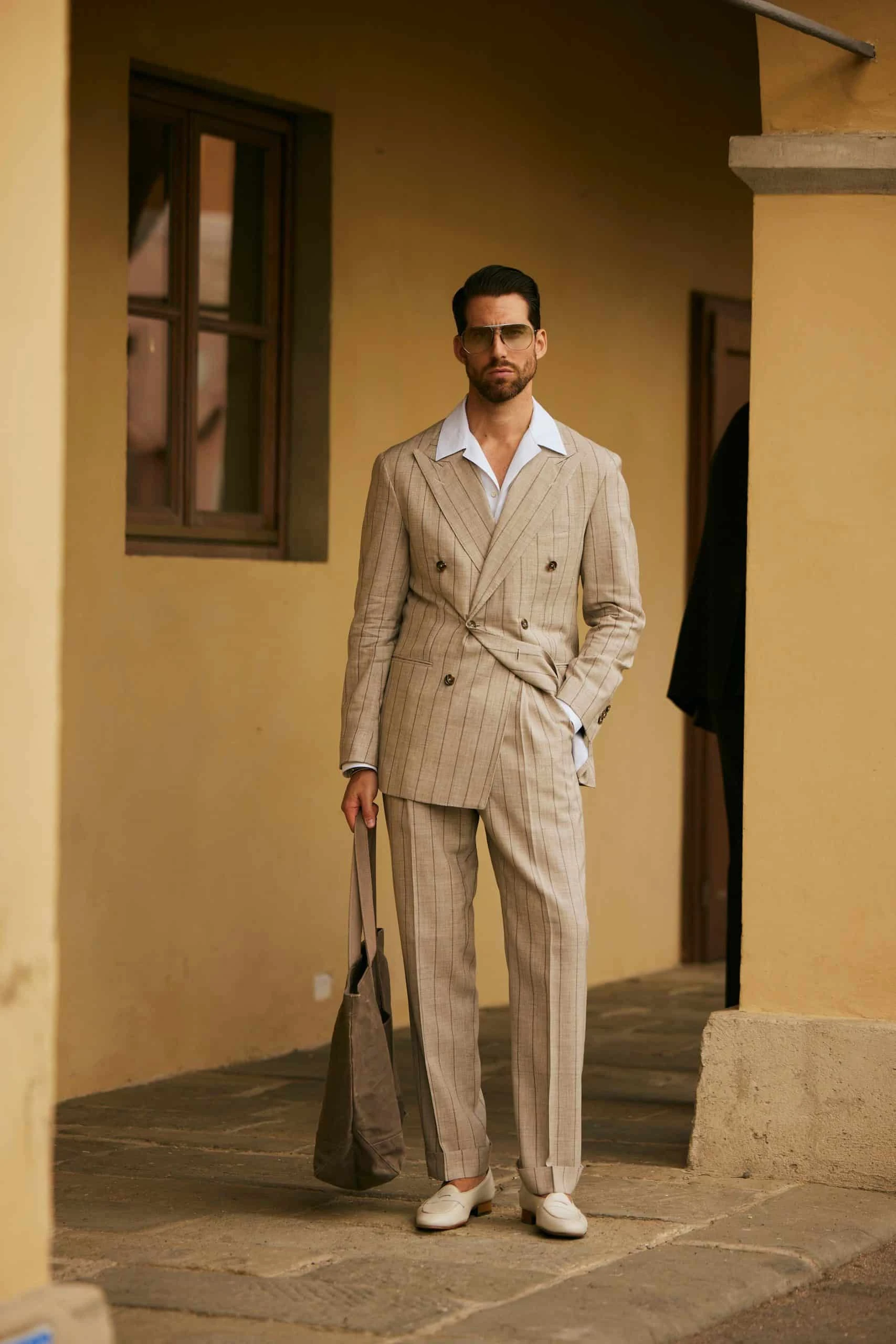 carlos domord at pitti uomo 104 in a taupe beige striped suit and a camp collar linen shirt by mond of copenhagen