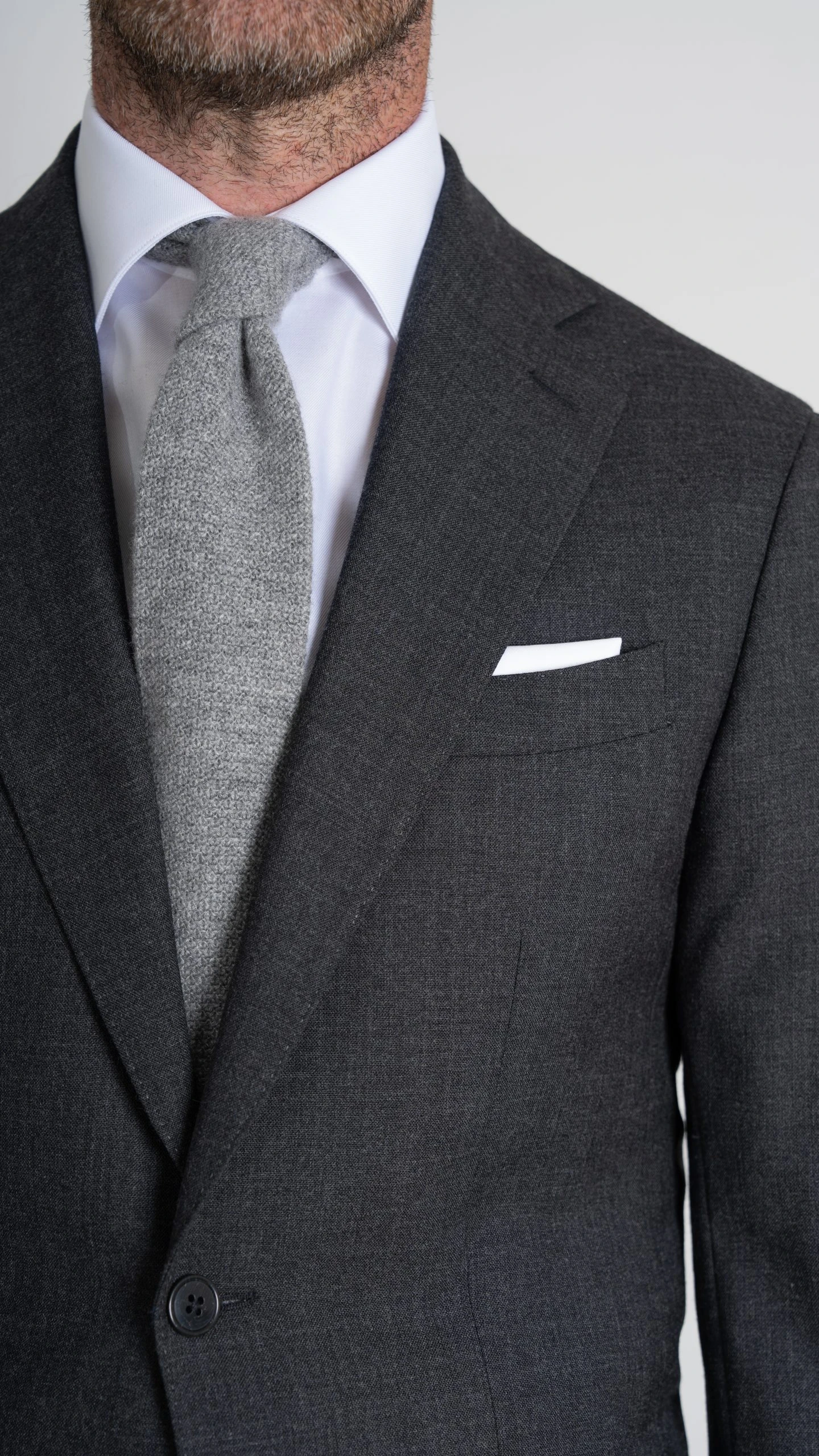 closeup of dark grey suit in twistair fabric and grey tie by Mond