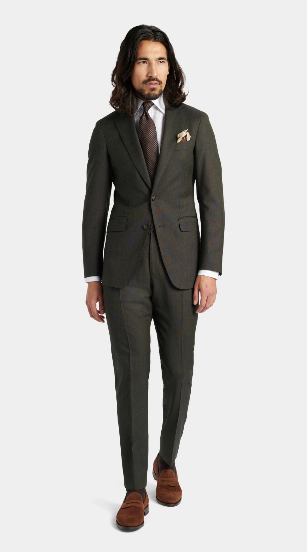 full body picture of a man in dark forest Green three piece wedding suit, with a beige pocket square and brown suede leather loafers