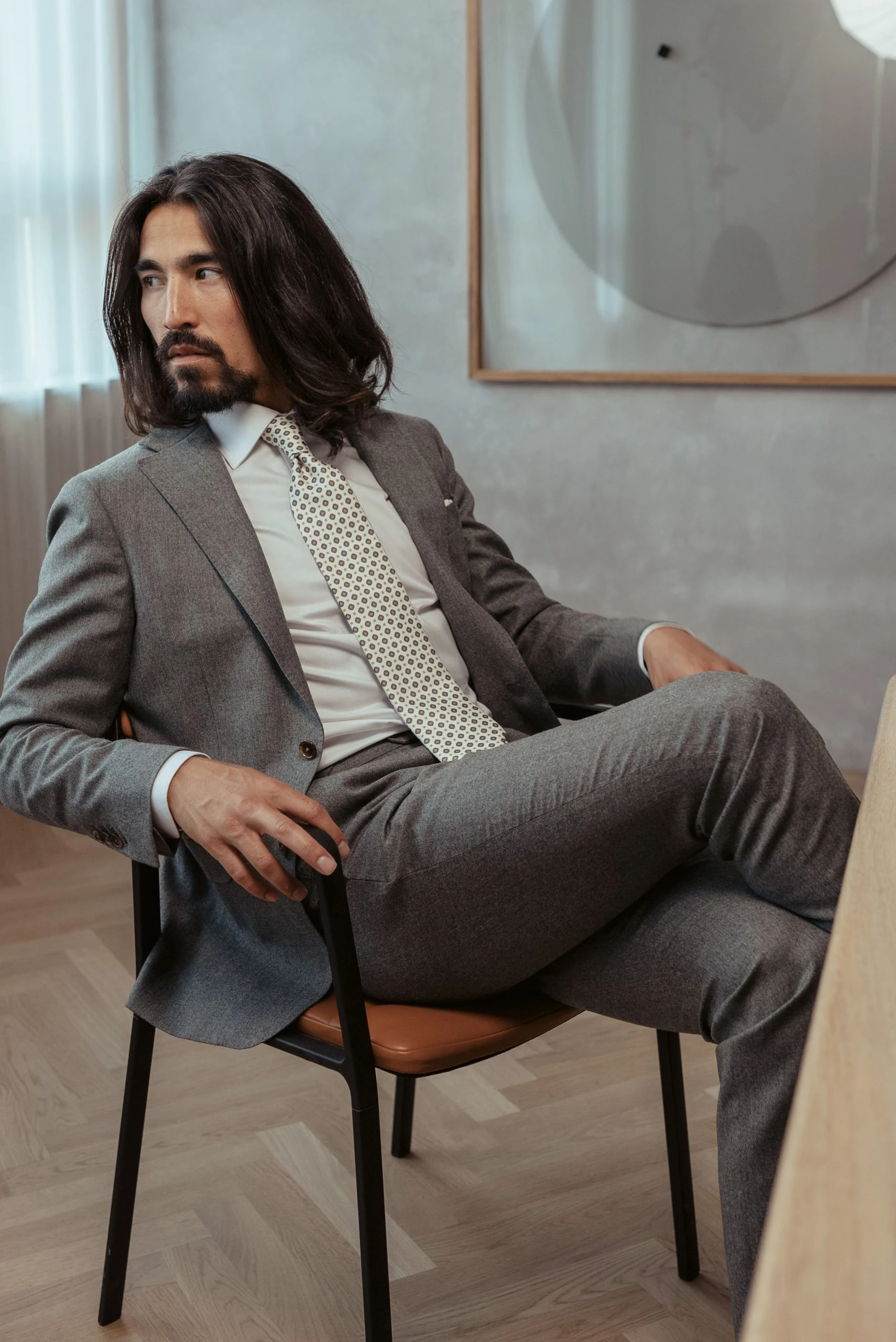 man sitting in two-piece grey suit custom made by mond