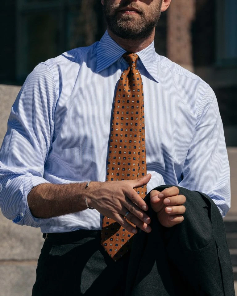 the light blue stripe oxford shirt by mond with an orange tie, worn by Andreas Weinås