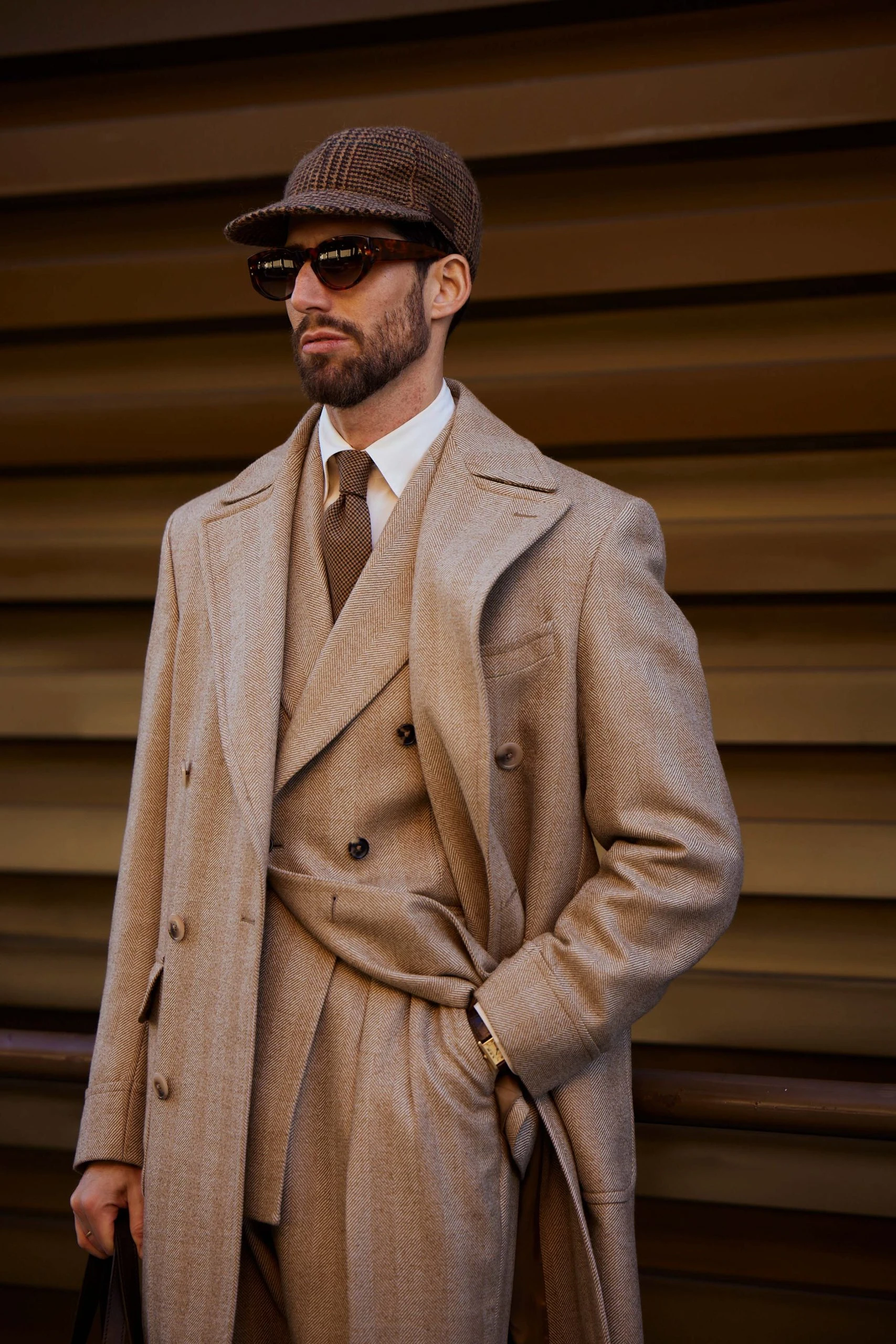 carlos domord at pitti uomo wearing a custom made beige herringbone mond suit and overcoat