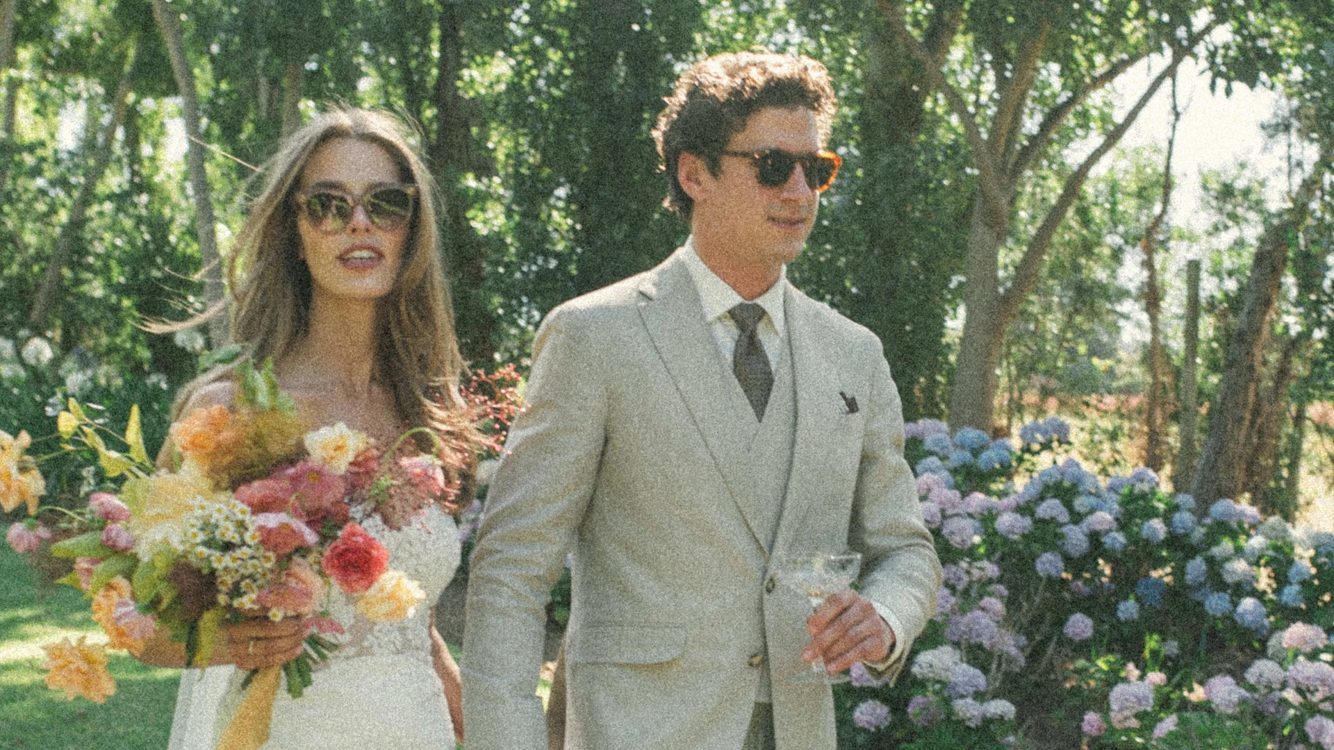 Bride and groom with sunglasses and tailored beige linen suit